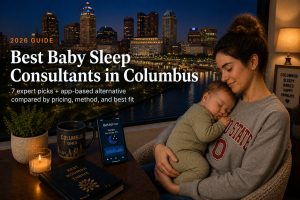 Bestsleepconsultantscolumbus | Betteroo Tired parent holding a sleeping baby near a downtown Columbus window, illustrating baby sleep consultants in Columbus.