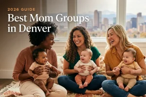 Three diverse moms holding their babies at a welcoming mom group meetup in Denver, with the Denver skyline with the Front Range mountains behind it in warm daylight behind them, illustrating a guide to the best mom groups in Denver for 2026