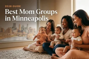 Three diverse moms holding their babies at a welcoming mom group meetup in Minneapolis, with the Minneapolis skyline above the Mississippi River in warm daylight behind them, illustrating a guide to the best mom groups in Minneapolis for 2026