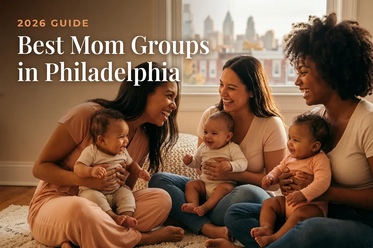 Three diverse moms holding their babies at a welcoming mom group meetup in Philadelphia, with the Philadelphia skyline and rowhomes in warm afternoon light behind them, illustrating a guide to the best mom groups in Philly for 2026