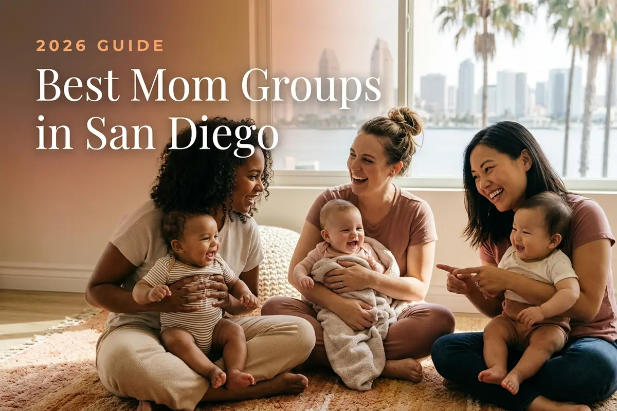 Three diverse moms holding their babies at a welcoming mom group meetup in San Diego, with the San Diego skyline along the bay with palm trees in bright coastal light behind them, illustrating a guide to the best mom groups in San Diego for 2026
