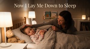 A parent tucking a child into bed at night with small hands folded in prayer, illustrating the Now I Lay Me Down to Sleep bedtime prayer.