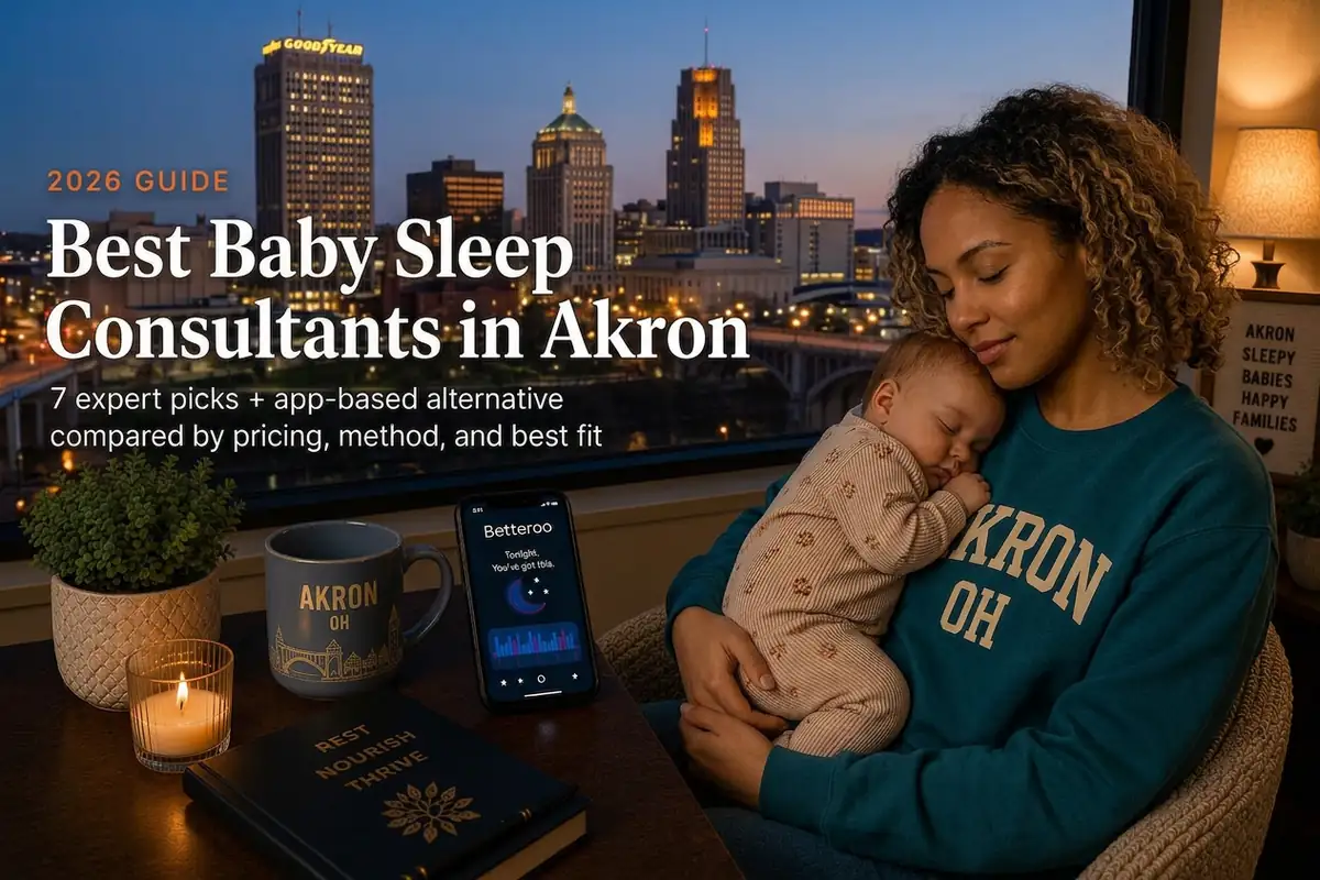 A mother cradling her sleeping baby by a window over the Akron skyline at dusk, best baby sleep consultants in Akron