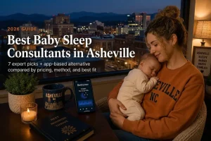 Mother cuddling a sleeping baby in a cozy living space with an Asheville city skyline outside the window; a phone screen shows the Betteroo app on the table beside a candle and mug.