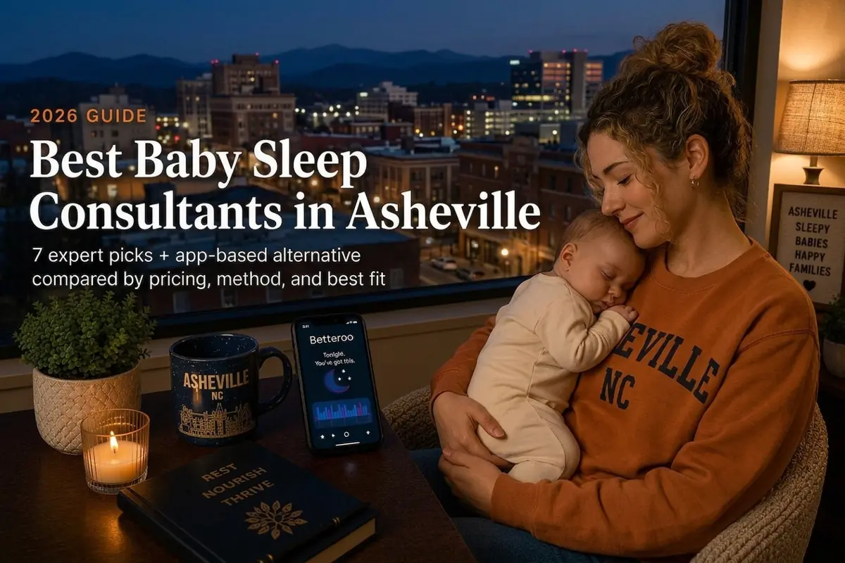 Mother cuddling a sleeping baby in a cozy living space with an Asheville city skyline outside the window; a phone screen shows the Betteroo app on the table beside a candle and mug.