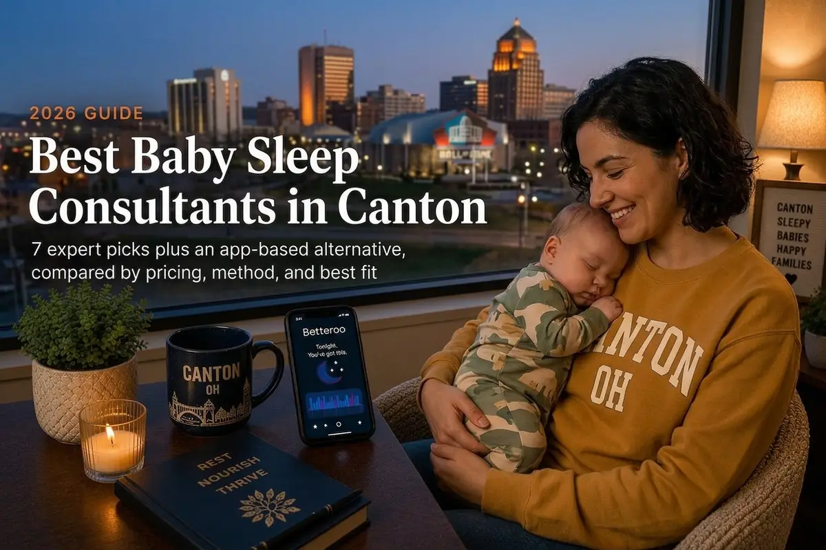 Mother holding a sleeping baby by a window over Canton's downtown evening skyline, baby sleep consultants in Canton.
