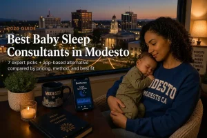 Mother holding a sleeping baby by a window at dusk, guide to the best baby sleep consultants in Modesto, California