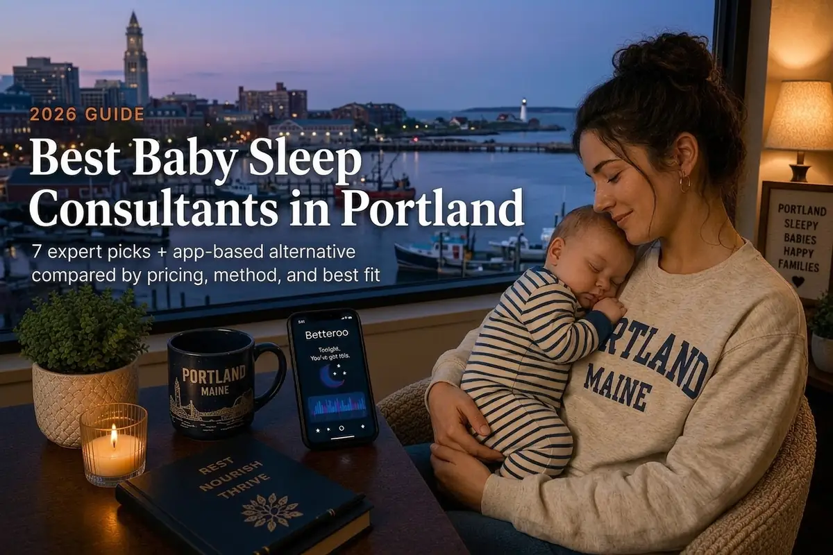 Tired Portland Maine mother holding her sleeping baby by a window at dusk, researching the best baby sleep consultants in Portland