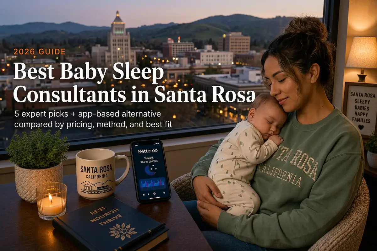 A tired mother cradles her sleeping baby by a window overlooking the downtown skyline and Sonoma County hills at dusk, representing baby sleep consultants in Santa Rosa.