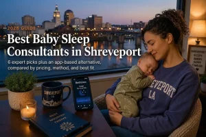 Mother holding a sleeping baby by a window over Shreveport's riverfront evening skyline, baby sleep consultants in Shreveport.