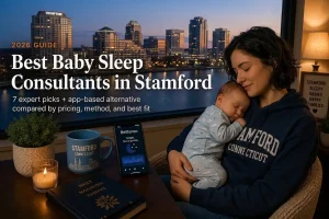 Mother holds sleeping baby by a window, guide to the best baby sleep consultants in Stamford, Connecticut