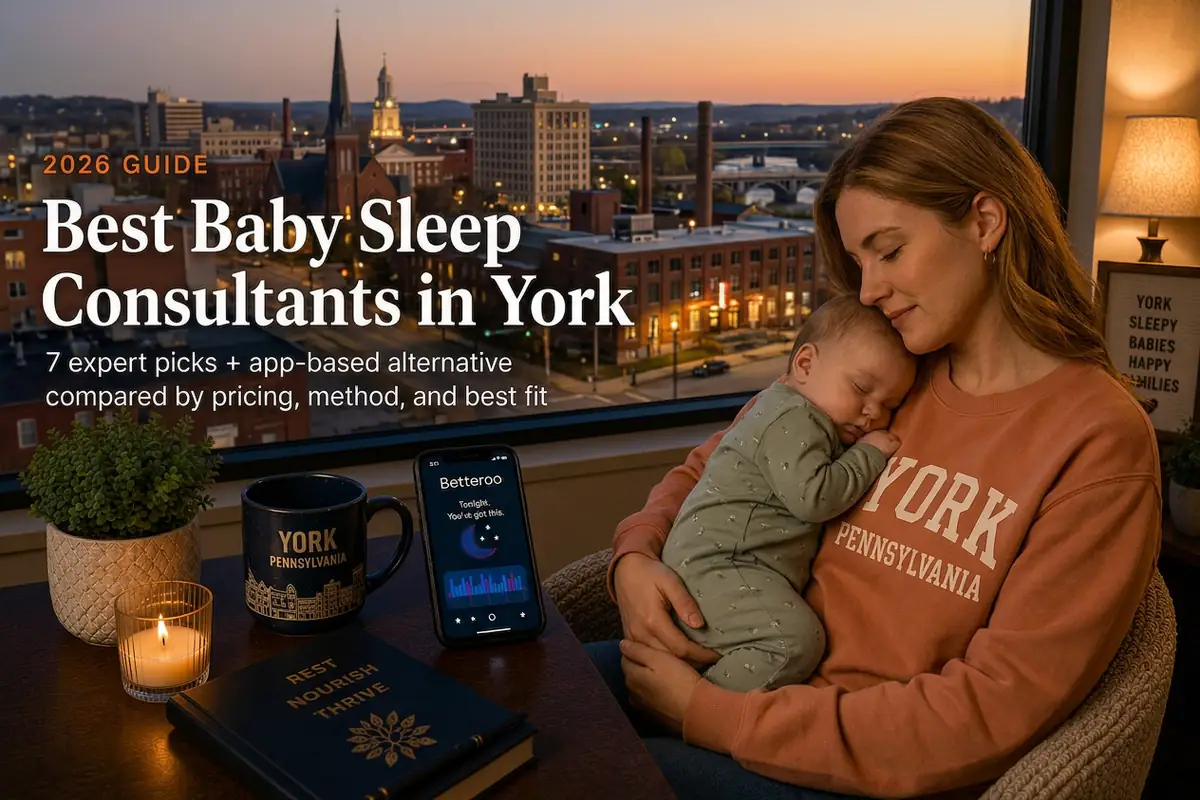 Tired York Pennsylvania mother holding her sleeping baby by a window at dusk, researching the best baby sleep consultants in York