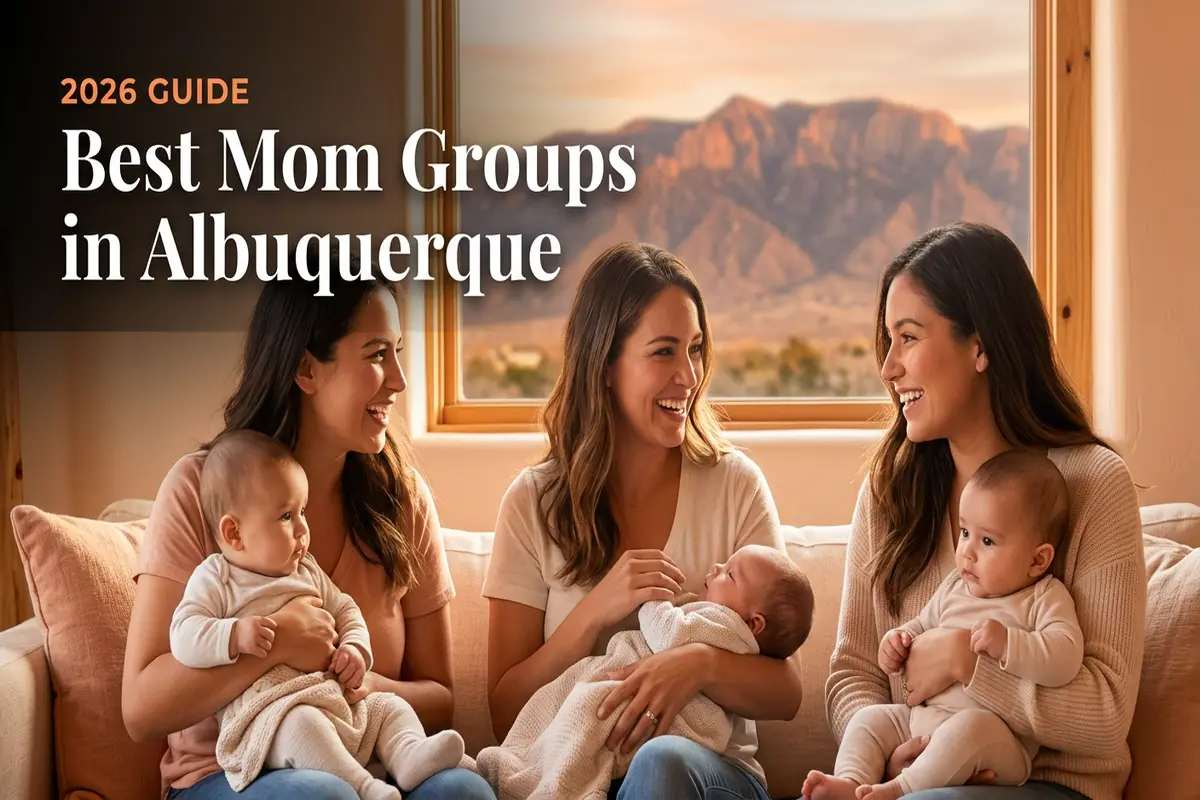 Cover image for a guide: four moms with babies on a sofa, chatting warmly by a window with mountains outside; title reads 'Best Mom Groups in Albuquerque' and '2026 Guide'.