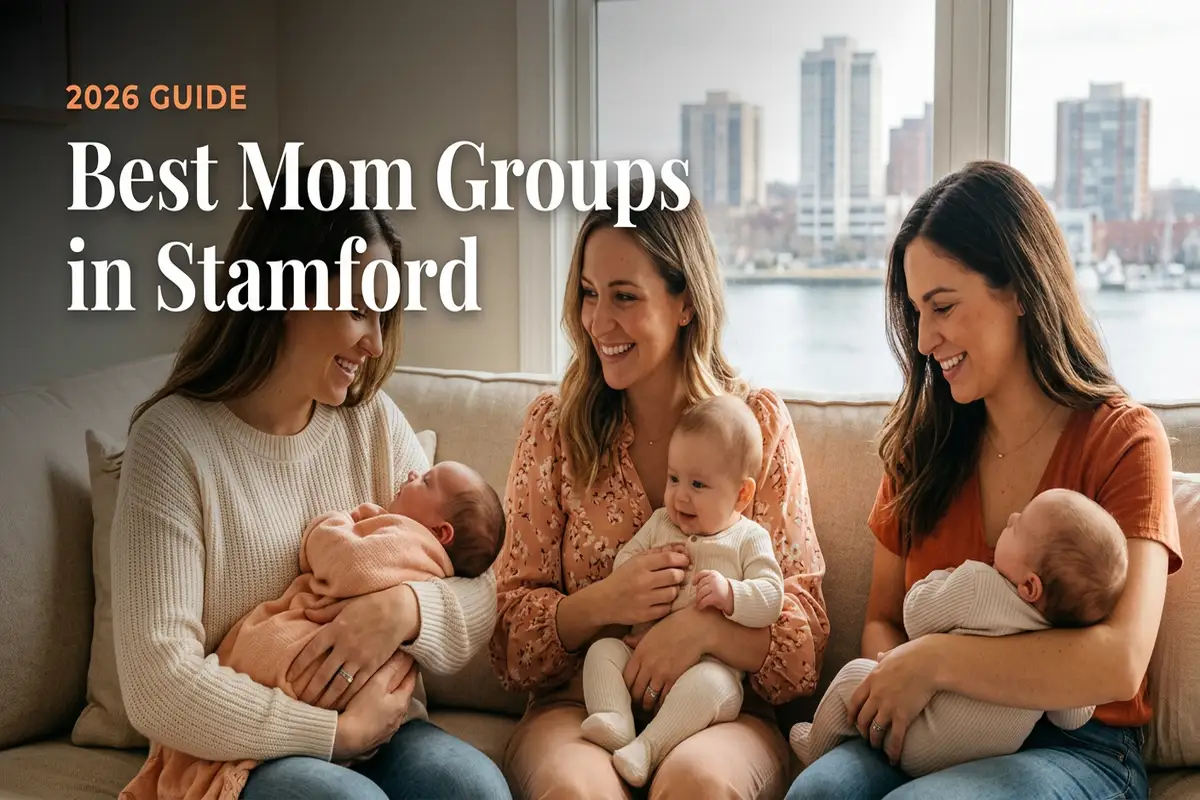 Cover image for 2026 guide: three smiling moms with babies on a sofa by a window overlooking a city, captioned 'Best Mom Groups in Stamford'.