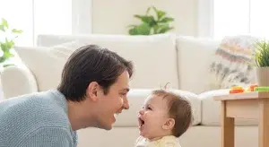 Smiling baby babbling and interacting face to face with a parent