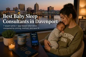 Mother holding a sleeping baby at dusk, best baby sleep consultants in Davenport, Iowa, river skyline behind.