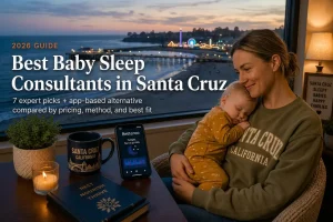 Mother holding a sleeping baby at dusk, best baby sleep consultants in Santa Cruz, California, coastal wharf behind.