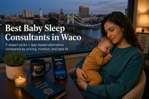Mother holding a sleeping baby at dusk, best baby sleep consultants in Waco, Texas, suspension bridge behind.