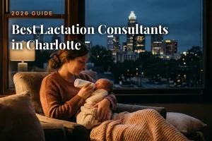 Mother feeding her baby by an evening window with the Charlotte skyline, cover image for the best lactation consultants in Charlotte guide