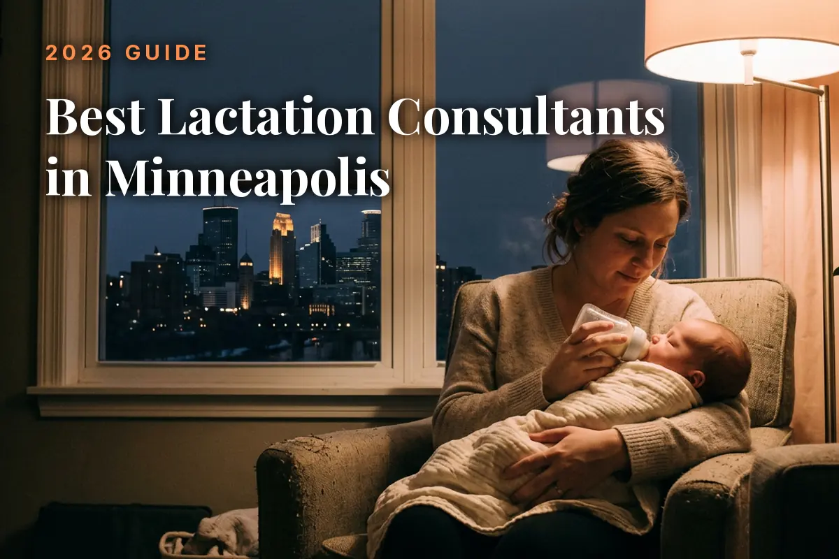 Mother feeding her baby by an evening window with the Minneapolis skyline, cover image for the best lactation consultants in Minneapolis guide