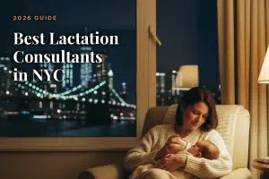 Nighttime city skyline through a window; a mother in a cream chair bottle-feeds her baby, with the title '2026 GUIDE Best Lactation Consultants in NYC'