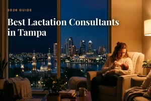 Mother breastfeeding her baby on a sofa by a window with Tampa's night skyline outside, as a 2026 guide hero image.