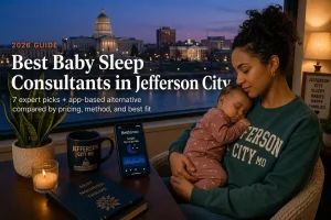 Mother holding a sleeping baby by a window overlooking the Jefferson City Missouri capitol skyline at dusk, guide to baby sleep consultants in Jefferson City