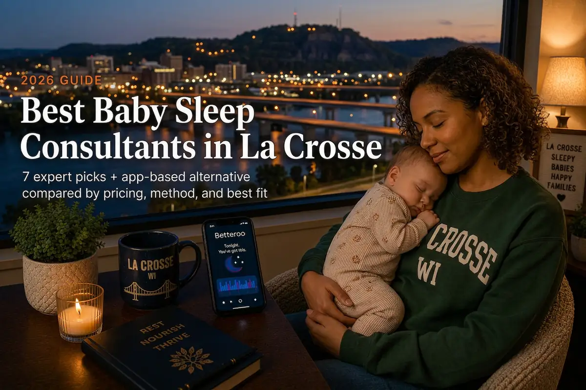 Mother holding a sleeping baby beside a window overlooking the Mississippi River bridges and Grandad Bluff, guide to baby sleep consultants in La Crosse Wisconsin