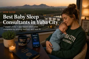 Mother and sleeping baby by a window over Yuba City orchards, baby sleep consultants in Yuba City