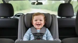 Toddler riding rear-facing in a convertible car seat with a snug harness