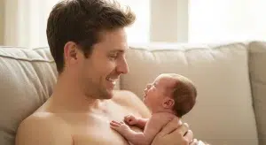 15 Things to Do with a Newborn simple Activities for the First 3 Months | Betteroo Father doing chest tummy time with his newborn baby on the couch