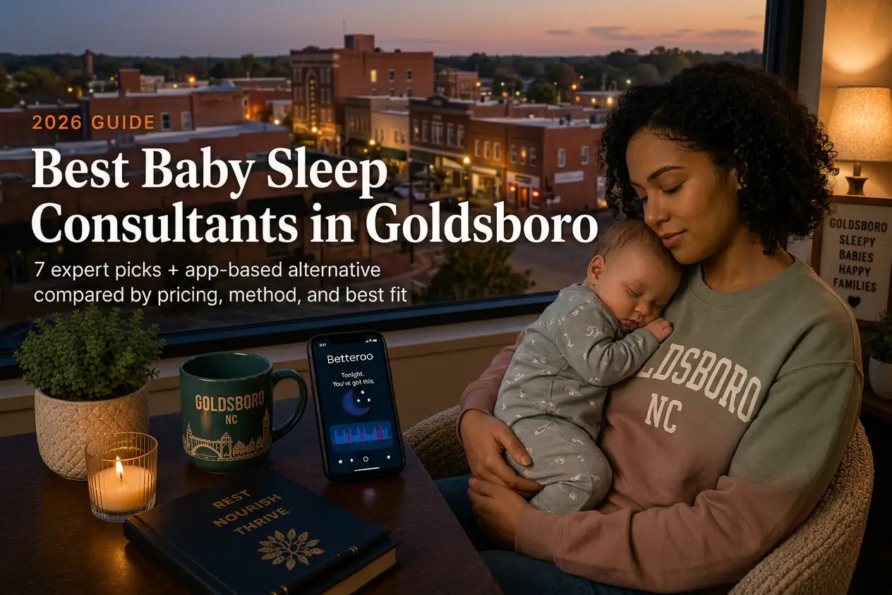 Mother holding a sleeping baby by a window overlooking downtown Goldsboro at dusk, baby sleep consultants in Goldsboro