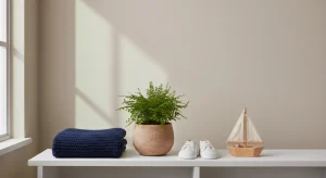 Boy Names That Start with D 147 D Names with Origins and Meanings | Betteroo Small potted fern, folded navy knit baby blanket, tiny canvas sneakers and a wooden toy boat on a white shelf